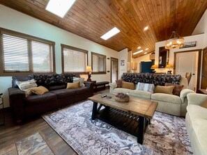 A spacious living room with a wooden ceiling, two sofas, a coffee table, and a patterned rug. - New Listing! 3BR Luxury Big Sky | Mountain Retreat (Big Sky)