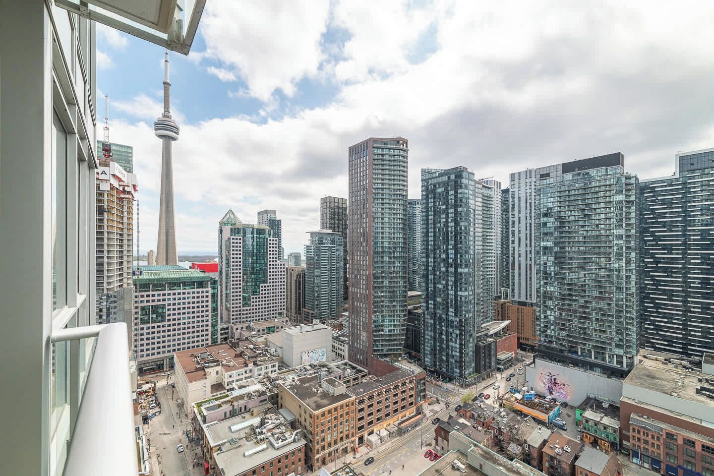 A cityscape with modern high-rise buildings, a prominent tower, and a busy street below.