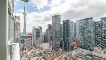 A cityscape with modern high-rise buildings, a prominent tower, and a busy street below.