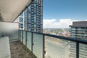 A balcony with a view of a cityscape, featuring high-rise buildings and a clear sky. - Modern Cozy Condo in the Heart of Toronto! | Parking Available (Toronto)