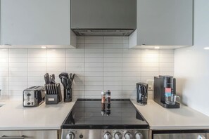 A modern kitchen with a gas stove, a coffee maker, and a toaster. - City View Condo, Walk to Eaton Centre, Sleeps 6! | Parking Available (Toronto)