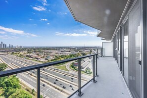 Ein Balkon mit Stadtblick auf eine Autobahn und Gebäude.