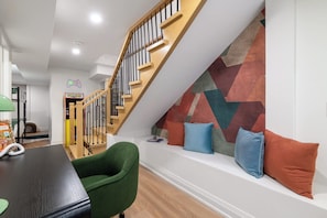 A modern interior with a staircase, a dining area, and a colorful geometric wall design. - Designer Trinity Bellwoods Gem Sleeps 12 Arcade | Parking Available (Toronto)