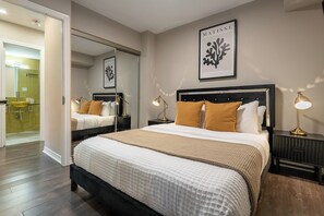 A bedroom with a large bed, bedside tables, a mirror, and a framed artwork on the wall. - Lux 3BR Townhouse with Private Patio! | Parking Available (Toronto)