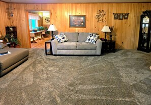 A living room with a grey sofa, two patterned throw pillows, a coffee table, and a lamp. - Starlight Retreat located near Pictured Rocks and access to ATV/Snowmobile Trail (Shingleton)