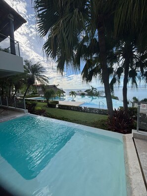 A swimming pool with a view of the ocean and palm trees. - The Perfect Sunset at Cima 3 Vallarta: Ocean View and Pool (Puerto Vallarta)