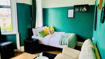 A bedroom with a bed, bedside table, and a chair.