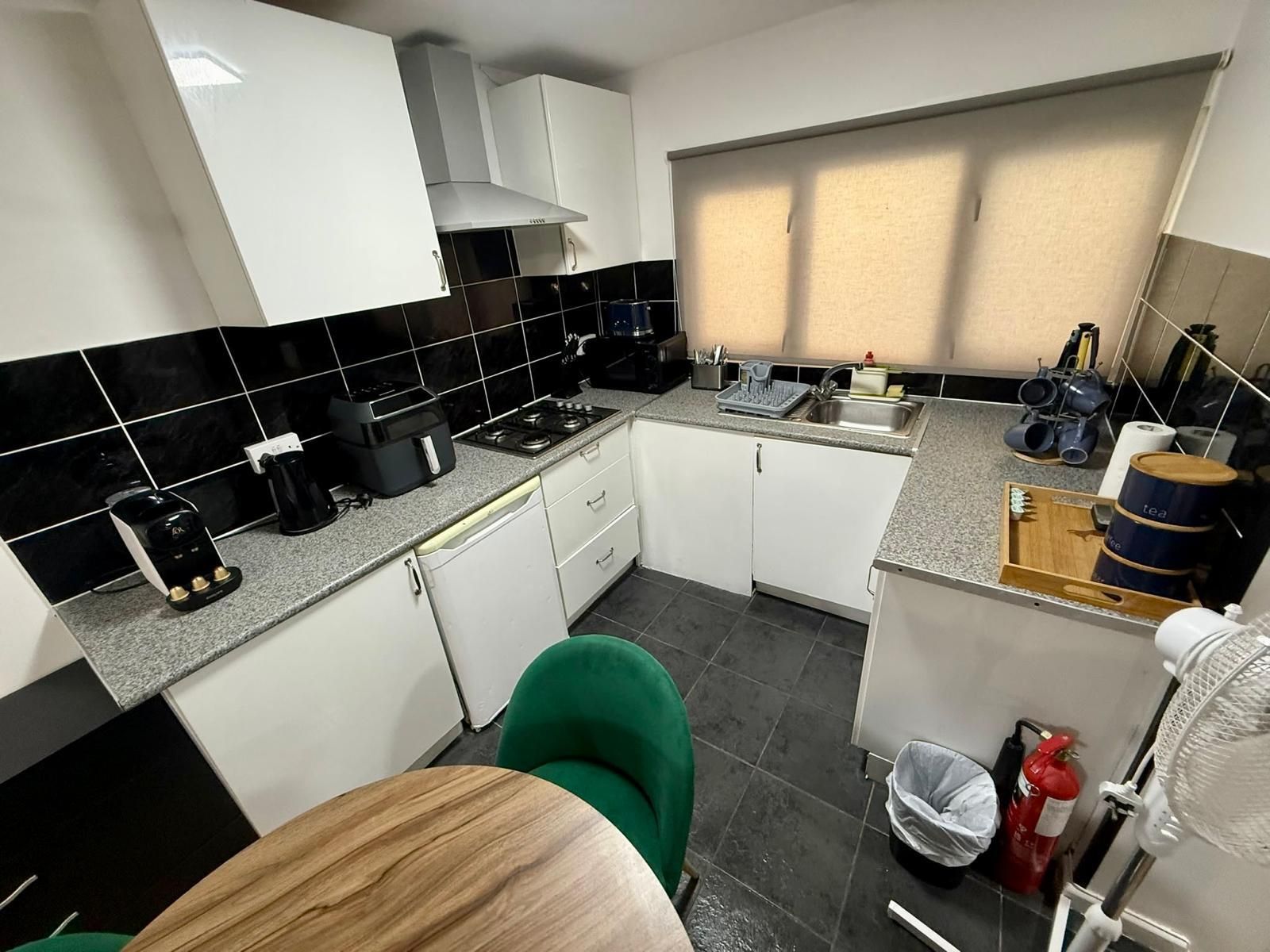 A compact kitchen with a gas stove, coffee maker, and a sink.