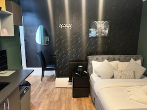A bedroom with a bed, bedside tables, a chair, a desk, and a mirror. - Dudy Studios at Brighton city center (Brighton and Hove)