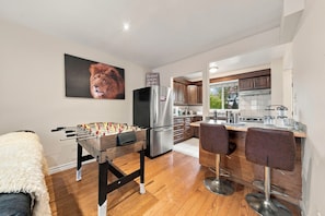 A modern kitchen with a foosball table, a refrigerator, and bar stools. - Spacious Toronto nest 6BR/4.5BA, Free Parking, 2 kitchens near 401 & Zoo (Toronto)