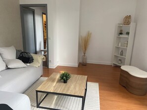 Een moderne woonkamer met een bank, salontafel en een boekenkast.