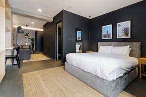 A modern bedroom with a large bed, a desk, and a chair. There are two framed pictures on the wall. - w* | Enchanting Loft w/ Balcony in Tabacalera (Ciudad de México)