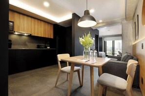 A modern kitchen with wooden cabinets, a dining table with two chairs, and a pendant light. - w* | Enchanting Loft w/ Balcony in Tabacalera (Ciudad de México)
