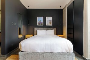A modern hotel room with a large bed, two bedside tables, a mirror, and two framed pictures on the wall. - w* | Enchanting Loft w/ Balcony in Tabacalera (Ciudad de México)