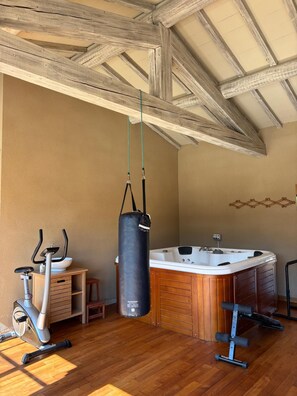 A room with a wooden ceiling, a hot tub, a punching bag, and exercise equipment. - A Magnificent Haven of Peace (Mas-Blanc-des-Alpilles)