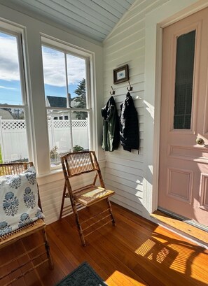 A room with a wooden chair, a bench, and a door with a picture frame. - Charming Newly Renovated Downtown Winter Harbor Retreat - Minutes to Schoodic! (Winter Harbor)