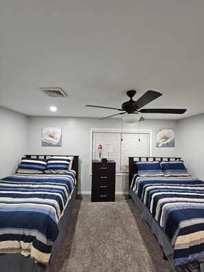 A bedroom with two beds, a ceiling fan, a window with blinds, and a dresser. - Stunning Poconos Mountain Retreat with Spacious Rooms, Pool Table and Family Fun (Tobyhanna)