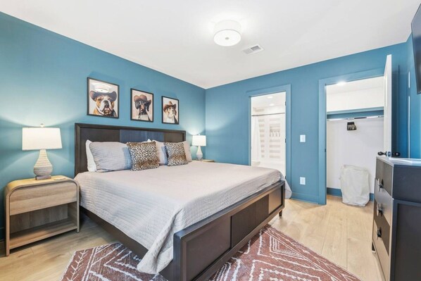 A bedroom with a bed, nightstands, a dresser, and a mirror. - Rooftop with TV, Dining, and BBQ Grill - 3 mi Downtown + Garage (Nashville)