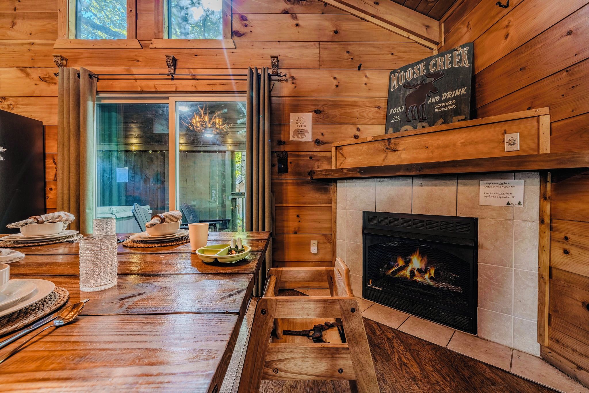 A cozy cabin interior with a wooden interior, a fireplace, and a sign indicating it is Moose Creek.