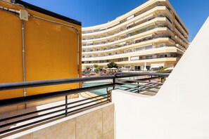 Ett hotell med flera våningar, balkonger, en swimmingpool och utomhusområden med sittplatser.
