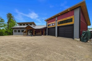 Ein zweistöckiges Gebäude mit Garage und überdachter Veranda.