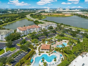 A resort with a swimming pool, parking, and a view of the surrounding area. - Vista Cay 3BR Near Universal & Epic Universe (Orlando)