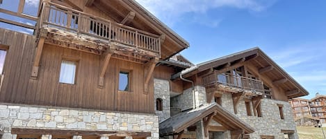A multi-story building with wooden balconies and stone walls.