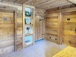 A wooden interior with a bookshelf, a door labeled 'TERRE,' and a blue wall. - Luxury apartment, parking, Wi-Fi - 4 guests (Montvalezan-La Rosière)