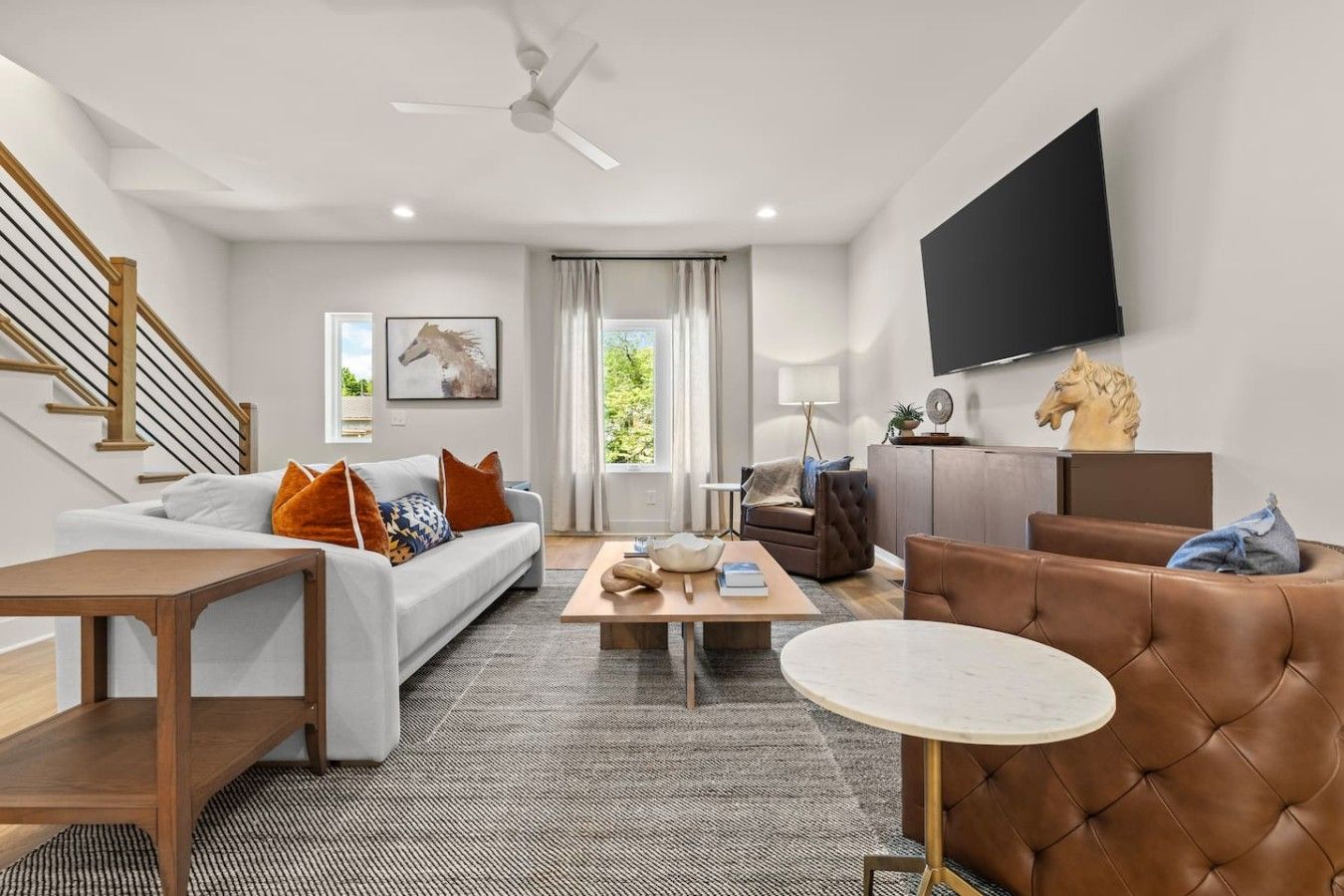 A modern living room with a sofa, coffee table, and a television mounted on the wall.