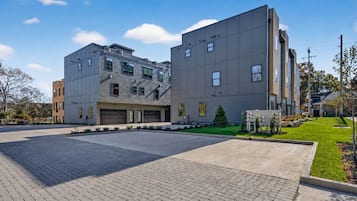 A modern building with a garage, paved driveway, and well-maintained lawn.
