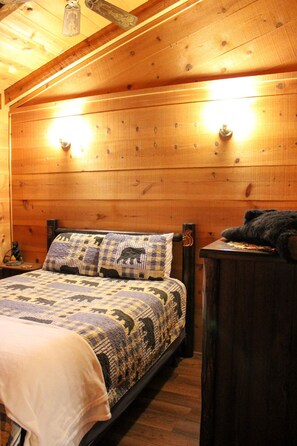 A wooden cabin bedroom with a bed, a dresser, and a nightstand. - 47 Bear Ridge cozy 2 bedroom 1 bathroom cabin. Perfect getaway (Sautee)