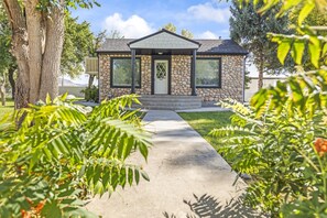 A stone house with a front porch, a mailbox, and a clear sky. - Cozy Salina Home w Patio, Yard & Full Kitchen! (Salina)