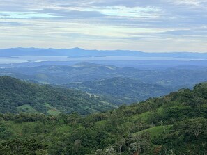 Vista panorâmica de uma paisagem montanhosa com um vale e massas de água ao longe.
