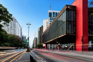 A city street with modern buildings, a traffic light, and a pedestrian crossing. - apartamento em São Paulo (São Paulo)