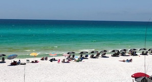 A beach with white sand and a clear blue sea. There are several umbrellas and beach chairs. - Beachside Escape at the Gulfplace with Pools, Hot Tubs and Fine/Casual Dinning (Santa Rosa Beach)