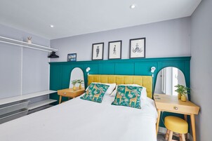 A modern bedroom with a bed, a desk, and a chair.