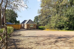 A single-story house with a gravel driveway and a wooden fence. - Chapel Cottage | By My Getaways (Brighton)