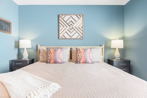 A bedroom with a bed, two bedside tables, a headboard, and a wall-mounted decorative piece. - Rooftop Deck with BBQ & TV, 3 Miles to Downtown, Garage (Nashville)