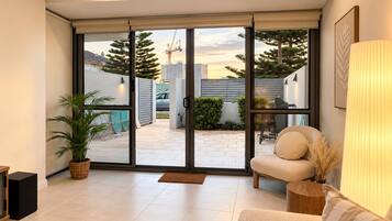 A modern living room with a sliding glass door leading to an outdoor patio area.