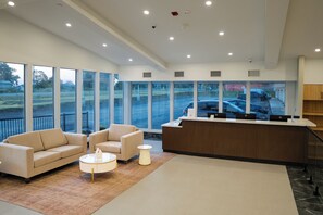 A modern reception area with a sofa set, a coffee table, and a reception desk. - Fully Furnished Two Queen Kitchen Suite, Ridgetown, Chatham-Kent, ON. Skye Hotel (Ridgetown)