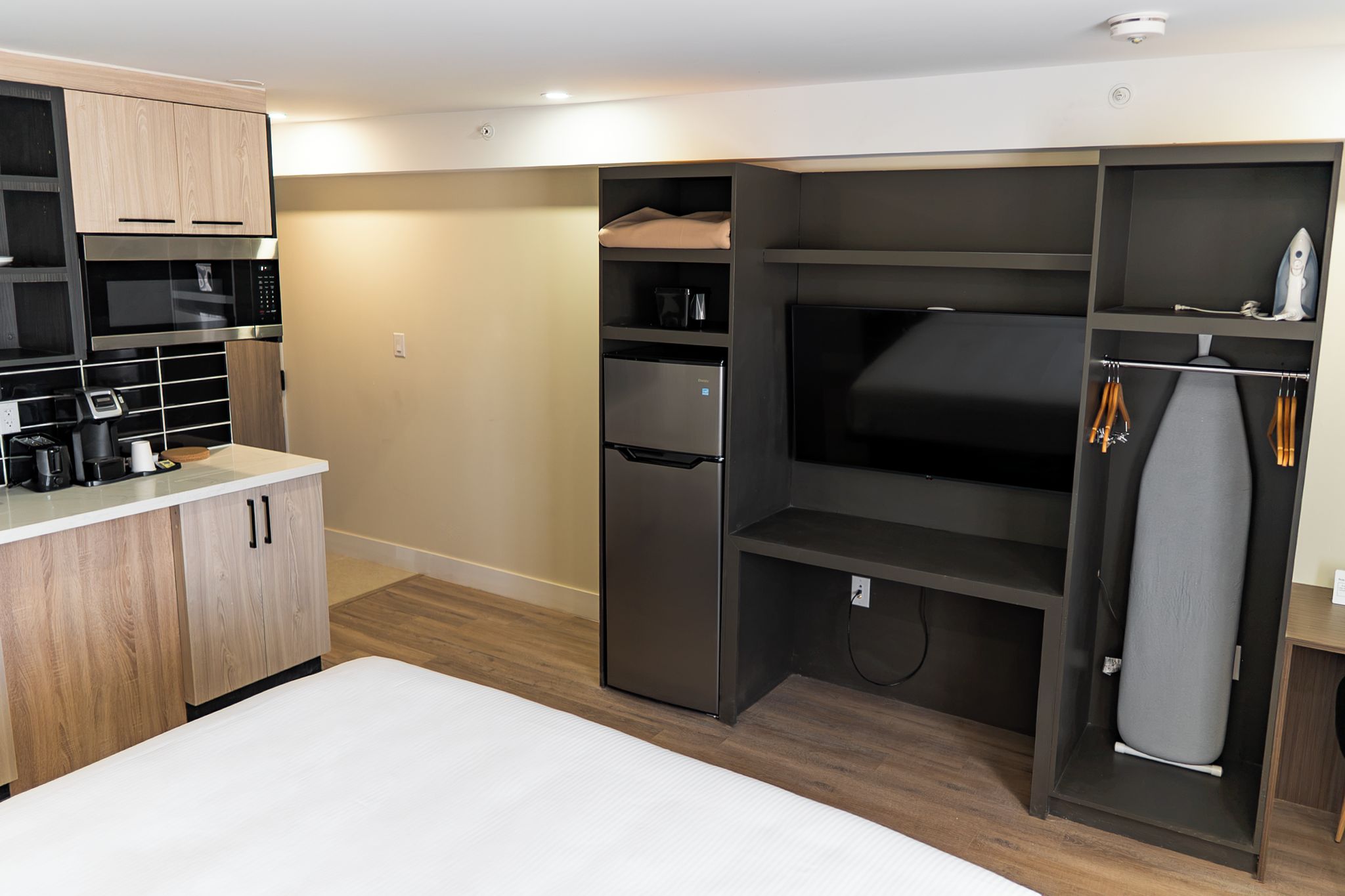 A compact kitchenette with a microwave, coffee maker, and toaster.