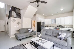 Un appartement moderne comprenant un salon, une cuisine et un escalier.