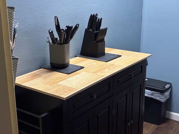 A kitchen counter with two knife holders and a trash bin.