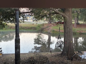 A pond with a hammock, chairs, and fishing rods. - Rustic Guesthouse on the Arkansas River  White Hall. (White Hall)