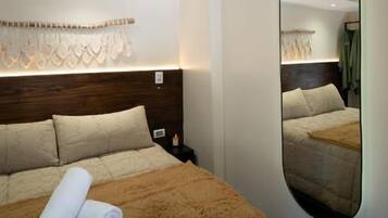 Una habitación de hotel con una cama grande, un espejo y un adorno en la pared.