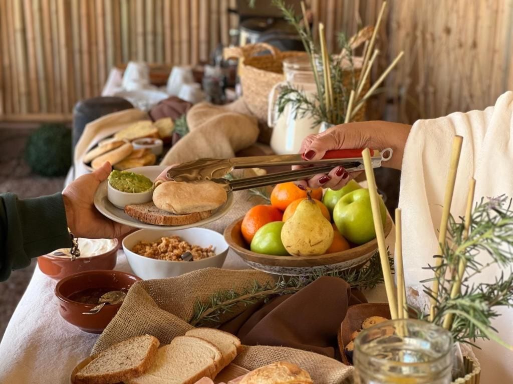 Une table dressée avec divers aliments, notamment du pain, des fruits et des condiments.