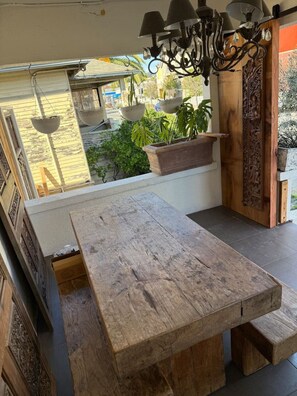 A wooden bench with a view of a street and plants outside. - Entire floor 4bed 3 bath conference table for 10 (San Rafael)