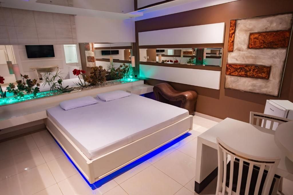 A modern bedroom with a bed, bedside table, and a small desk area.