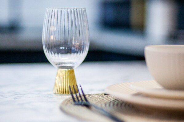 A dining table with a clear glass wine glass, a bowl, and cutlery. - The Vittoria | 2 BR | Wi-Fi | Workspace | Contractors/Leisure (Birmingham)