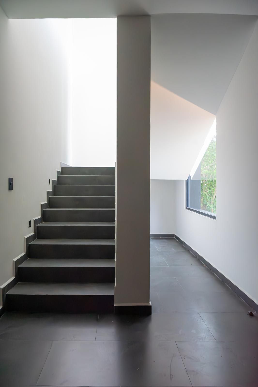 A modern interior with a staircase leading to a skylight.